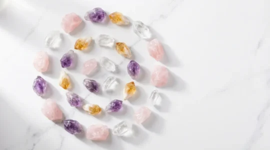 Cristales y gemas coloridas dispuestas armónicamente sobre una superficie de mármol con luz natural